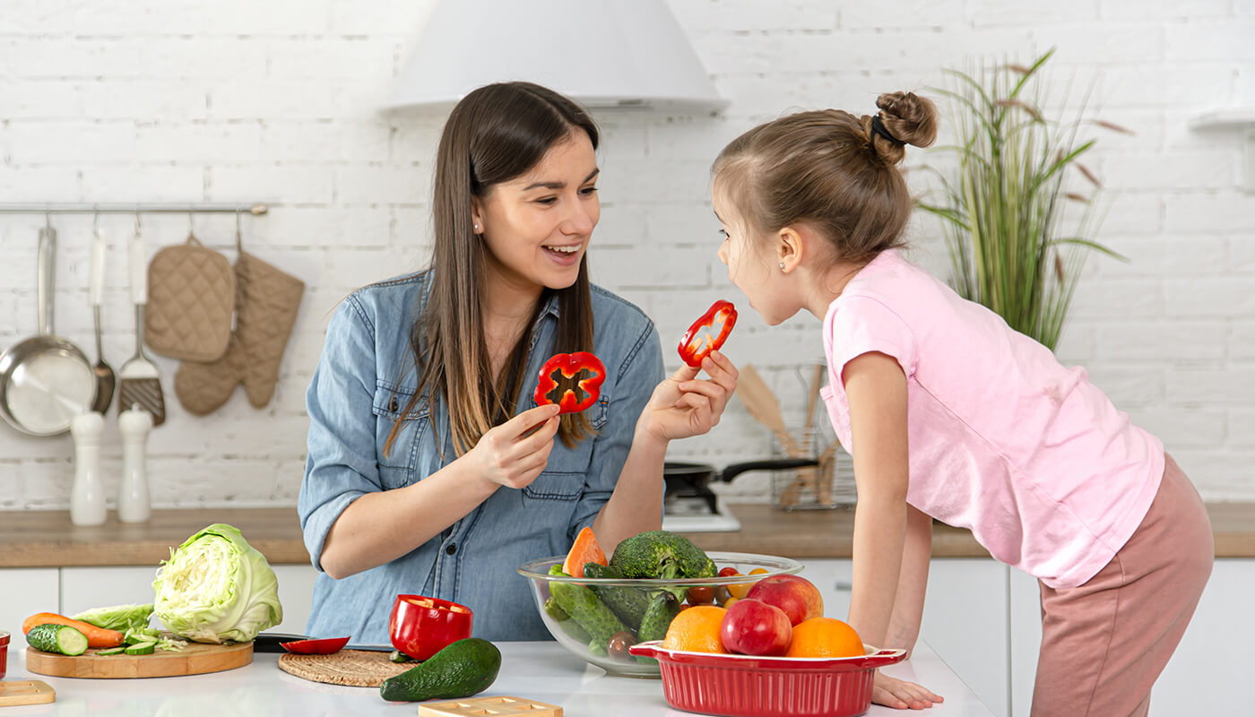 Madre alimentando a hija con dieta balanceada