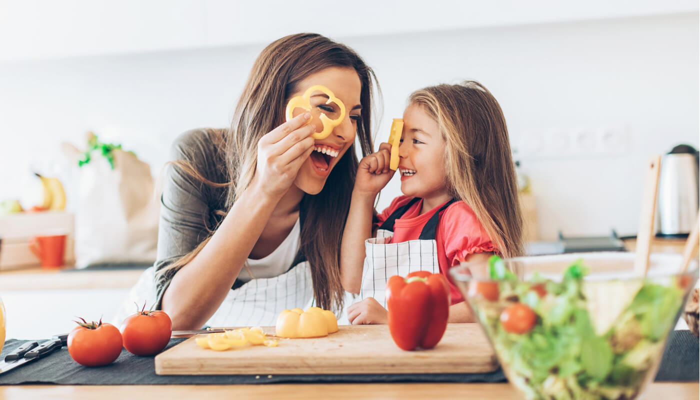 Madre enseñando a comer a su hija