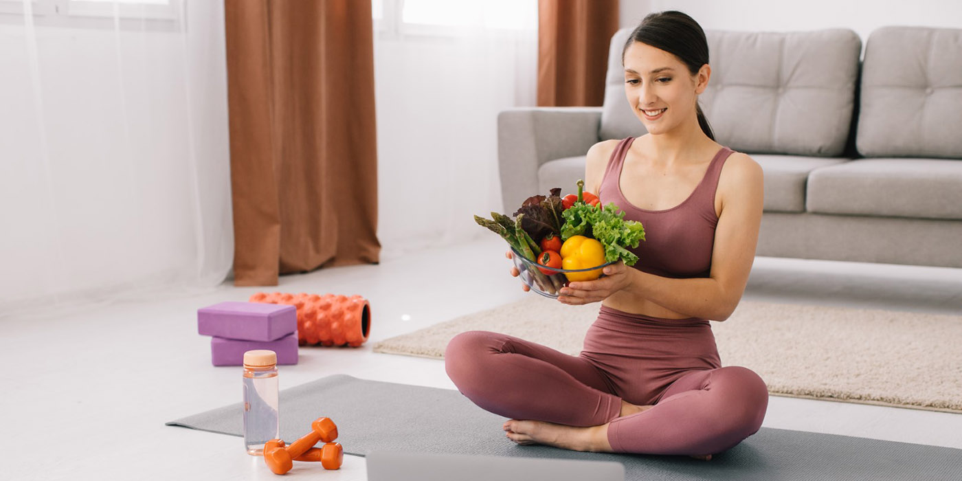 Chica haciendo yoga con alimentos en la mano